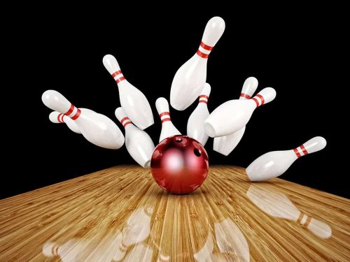Bowling pins being scattered by ball